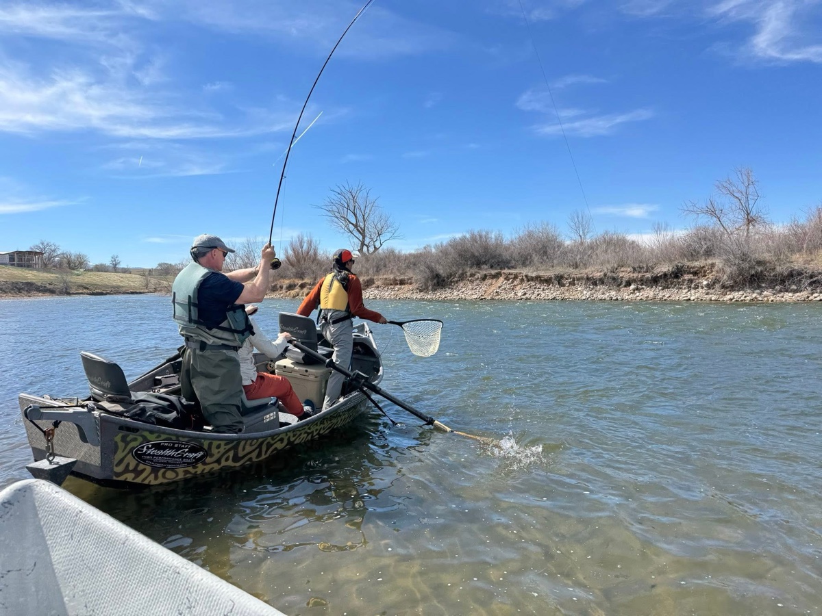 Anglers fishing from a drift boat on a Colorado river